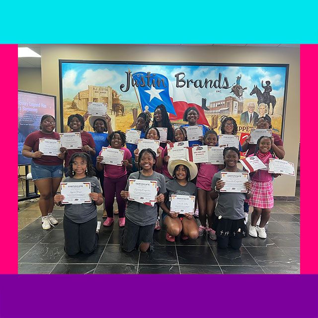 A group photo of teenage girls holding certificates and smiling for the camera.